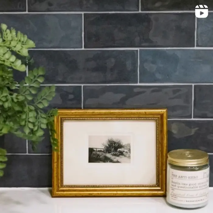 Interior Designers, Picture frame and candle leaning against a blue tile background